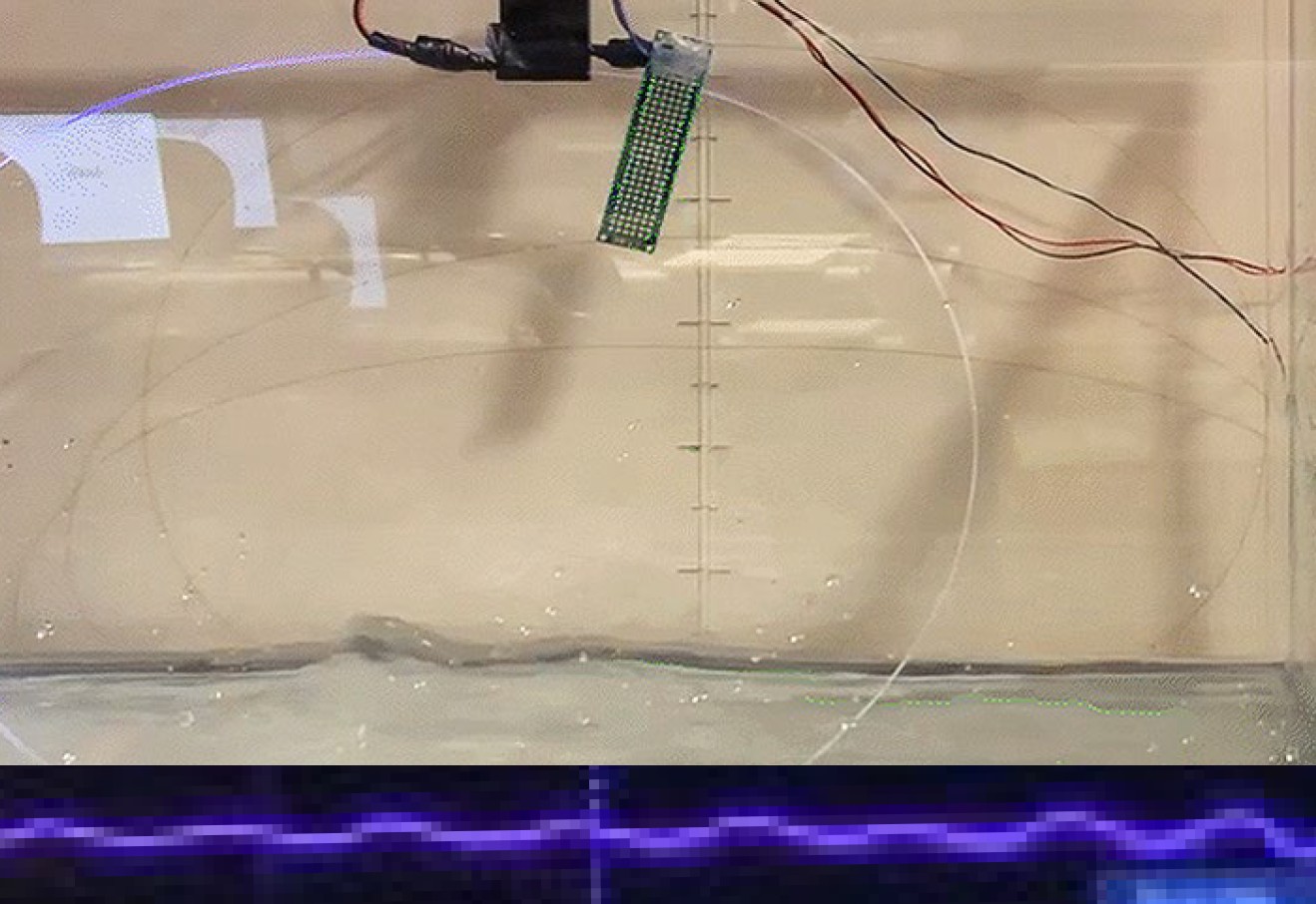 Glowing optical fibers woven through a geotextile breakwater prototype